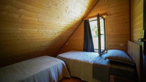 a attic room with two beds and a window at SkyGona Alpine Retreat in Ghebi