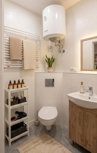 a white bathroom with a toilet and a sink at Lublin Aura Residence in Lublin