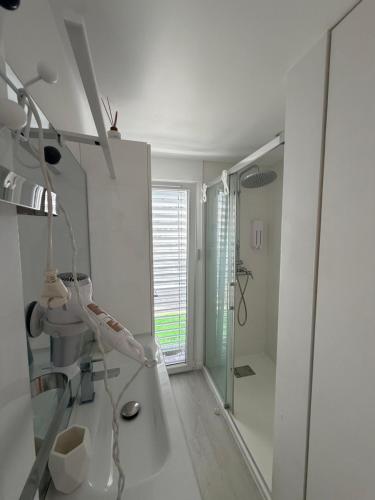 a white bathroom with a shower and a sink at Little White House in Anglet
