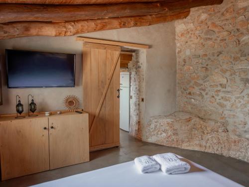a room with a television and a bed with towels at Can Rata in Tivenys