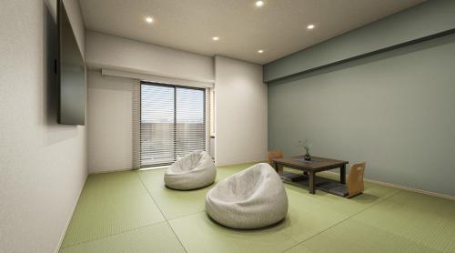 a living room with two white chairs and a table at 乃宿-noyado-博多 in Fukuoka