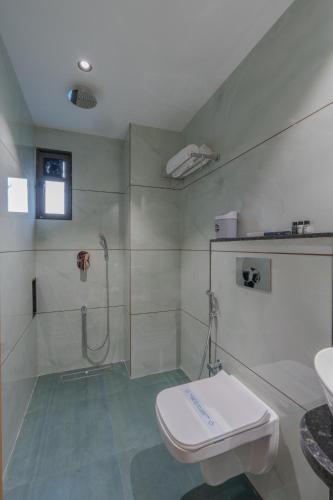 ein Badezimmer mit Dusche, Toilette und Waschbecken in der Unterkunft Hotel 7 skye in Surat
