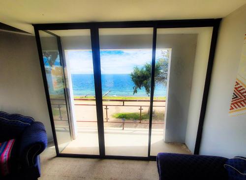 a room with a view of the ocean through a glass door at Lodge & Camping Suma Samawi in Copacabana