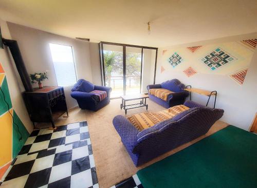 a living room with blue couches and a checkered floor at Lodge & Camping Suma Samawi in Copacabana
