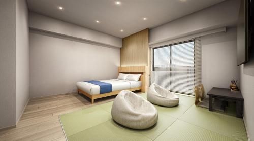 a bedroom with a bed and two chairs and a table at 乃宿-noyado-博多 in Fukuoka