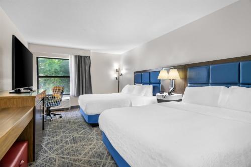 a hotel room with two beds and a television at Hampton Inn Portage in Portage