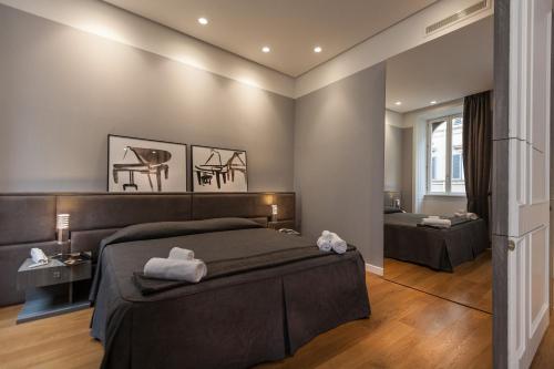 ローマにあるAmazing Suite Piazza Veneziaのベッドルーム1室(ベッド1台付)、デスクが備わるベッドルーム1室が備わります。