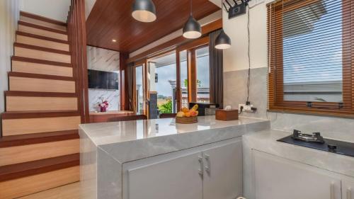 a kitchen with a counter top and some windows at Private Villa close to Ubud in Darmasaba