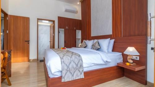 a bedroom with a white bed with a wooden headboard at Private Villa close to Ubud in Darmasaba