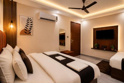 a bedroom with a large bed and a television at SG Royal Portico in Haridwār