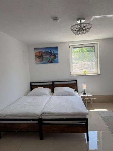 a bedroom with a bed and a window and a chandelier at Ferienwohnung Trinh 1 in Überlingen