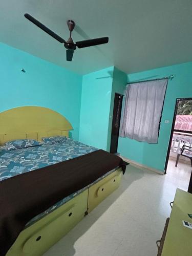 a bedroom with a bed with a ceiling fan at Dmello guesthouse in Palolem