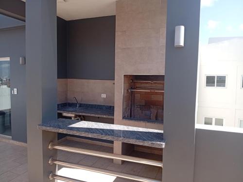 a kitchen with a counter with a fireplace at JG Hotel in Santa Cruz de la Sierra