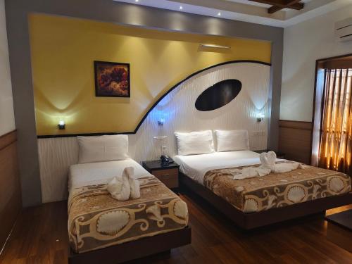 a hotel room with two beds with towels on them at Kohinoor Hotels in Erode