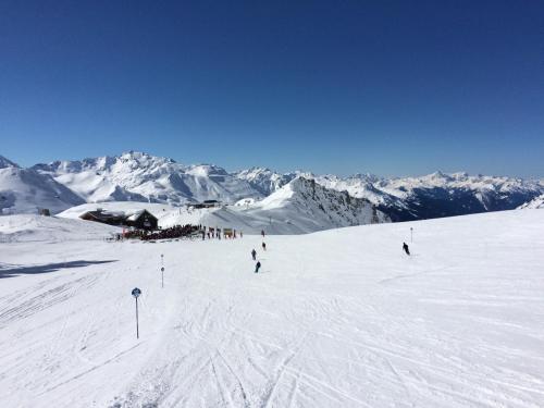 a group of people skiing down a snow covered mountain at Appartements Rendl in Sankt Anton am Arlberg
