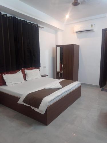 a bedroom with a large bed with black curtains at Hotel rose palace in Dehradun