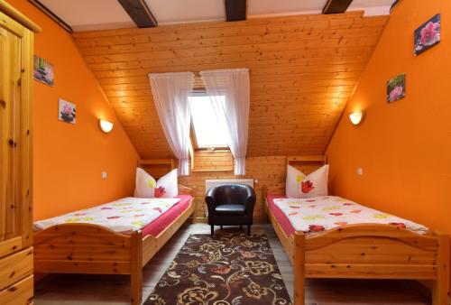 a room with two beds and a chair in it at Ferienhaus Richter in Drognitz