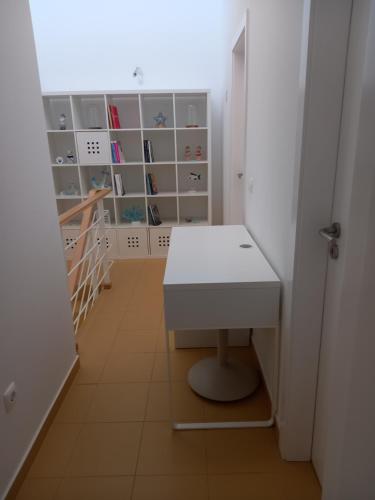 a small room with a desk and shelves at Charming Beach Villa Porto Santo in Porto Santo