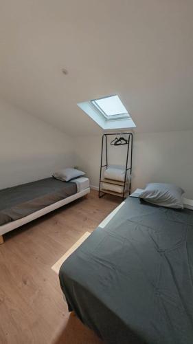 a room with two beds and a window on the wall at Clos de la Vigne Saint Roch in Crêches-sur-Saône