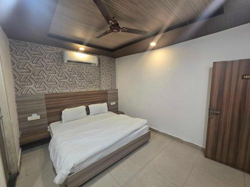 a bedroom with a bed and a ceiling fan at Collection O Guru Nanak Dev University Amritsar Formerly Hotel Tashi in Amritsar
