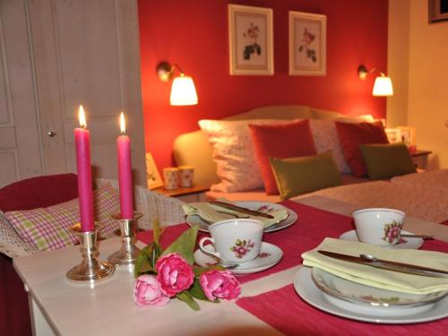 a table with two candles and plates and flowers at Appartementhaus Grill in Strobl