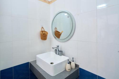 a white bathroom with a sink and a mirror at Sunny - Việt House in Kỳ Vĩ
