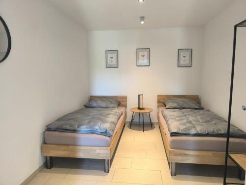 two twin beds in a room with a table at FeWo 180° MOSELWeitblick in Neumagen-Dhron