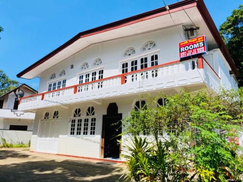 a white building with a sign in front of it at Hotel Kandy Village Inn in Kandy