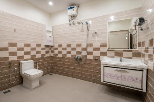 a bathroom with a toilet and a sink and a mirror at Heaven Stay in Varkala
