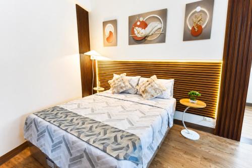 a bedroom with a large bed with a wooden headboard at Cebu Airport Layover Stay in Pusok