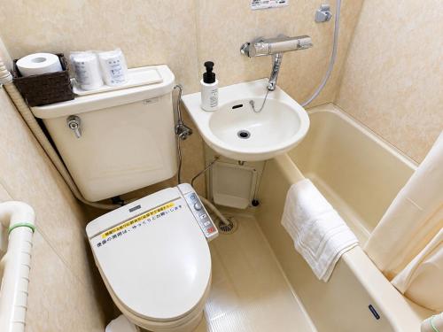 a small bathroom with a toilet and a sink at スマートホテル福島駅前店 in Fukushima