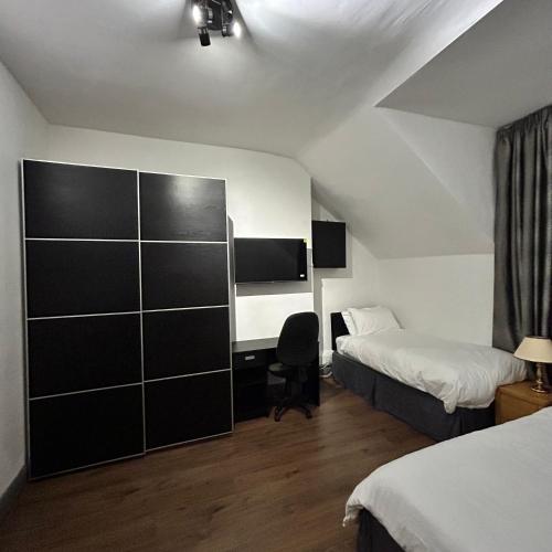 a hotel room with two beds and a desk at Haven Home 3 bedrooms near Sunderland City Centre Downstairs Shower with Toilet and Upstairs Bath with Toilet TV in each room in Sunderland