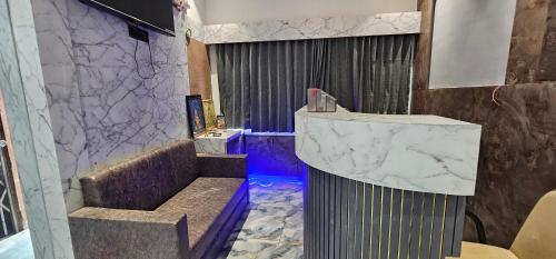 a bathroom with a sink and a marble wall at Hotel Prime Gold in Ahmedabad