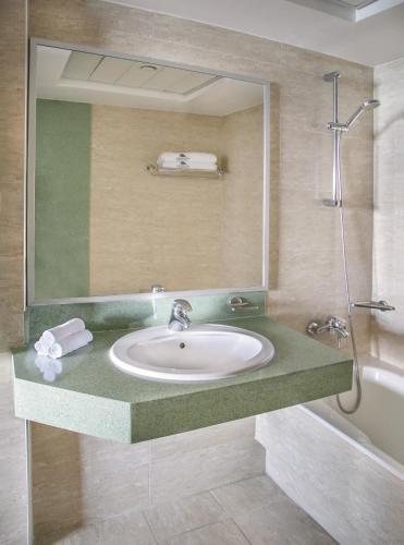 a bathroom with a sink and a shower at Atlantica Miramare Beach in Limassol