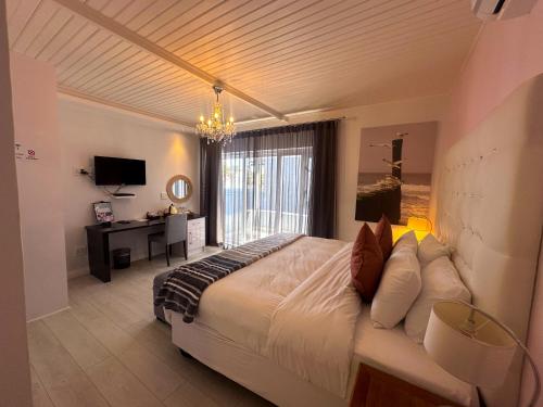 a bedroom with a large bed with a chandelier at La Flamingo Guesthouse in Walvis Bay