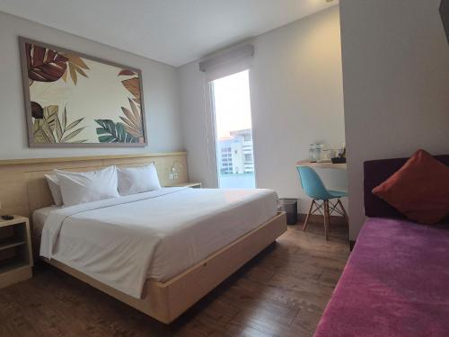 a bedroom with a large white bed and a window at Alltrue Lite Senen Jakarta in Jakarta