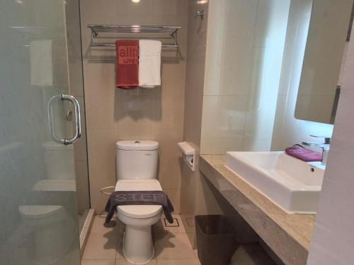 a bathroom with a toilet and a sink at Alltrue Lite Senen Jakarta in Jakarta