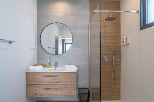 a bathroom with a sink and a shower with a mirror at Isaq Villa in Santa Cruz in Gaula