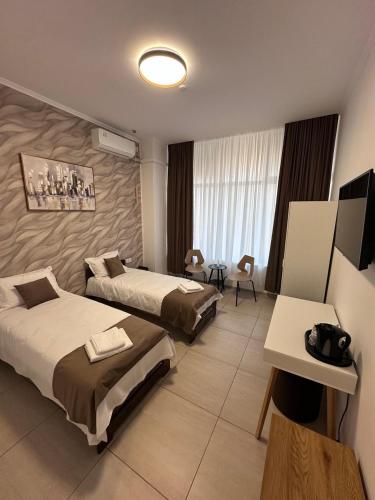a hotel room with two beds and a television at Rulers Smart Rooms in Satu Mare