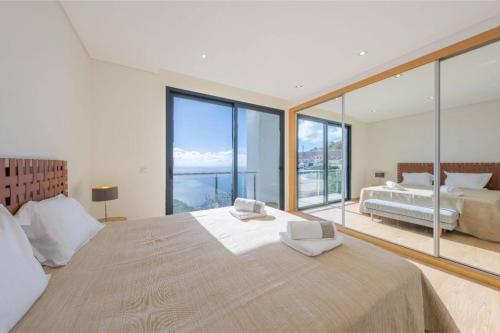 a bedroom with a large bed and large windows at Celeste Villa in Ribeira Brava