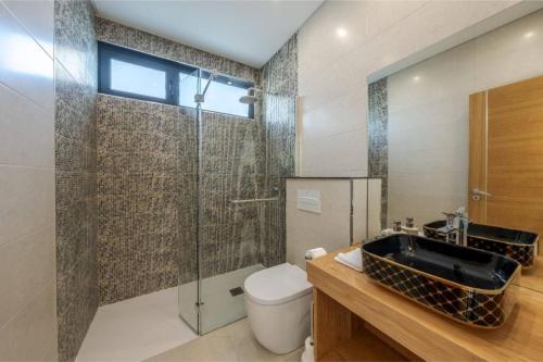 a bathroom with a sink and a toilet and a shower at Celeste Villa in Ribeira Brava