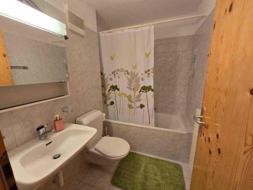 a bathroom with a sink and a toilet and a tub at ELAfora Studio in Salouf