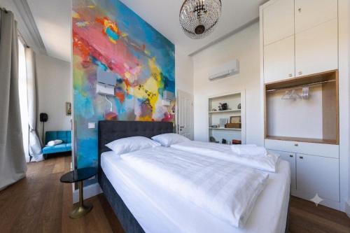 a bedroom with a bed and a painting on the wall at Karmeliterhof Studios & Suites in Boppard