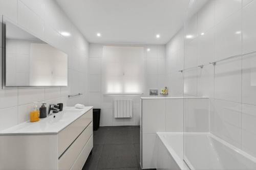 a white bathroom with a tub and a sink at Florentina Villa in Gaula