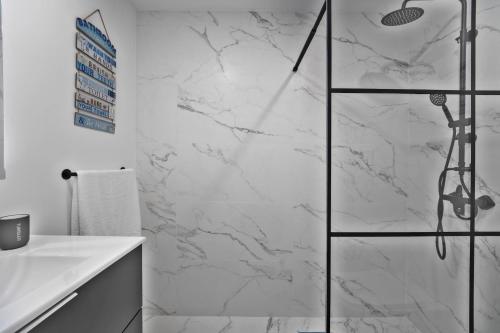 a bathroom with a shower with white marble walls at Casa da Telvina in Paul do Mar