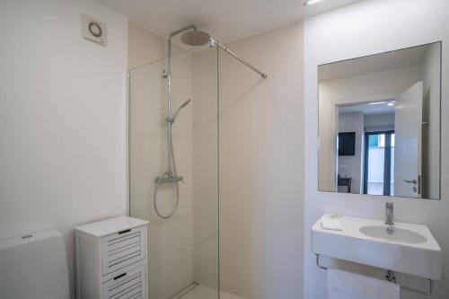 a white bathroom with a sink and a shower at Jardim Mar Flats in Jardim do Mar