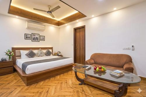 a bedroom with a bed and a couch and a table at Hotel Anand - Near Ganga Ram & BLK Hospital At Karol Bagh Metro Station in New Delhi