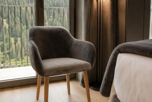a chair sitting in front of a window at Hotel Naudi Boutique Adults only in Soldeu