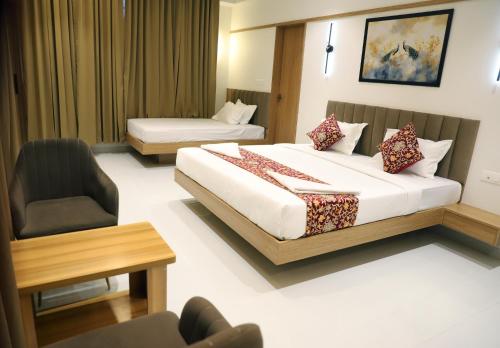 a hotel room with a large bed and a chair at Hotel Ellora Pride in Ellora