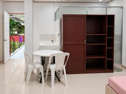 a kitchen with a table and two chairs and a cabinet at EnPensionne Hotel in Iloilo City